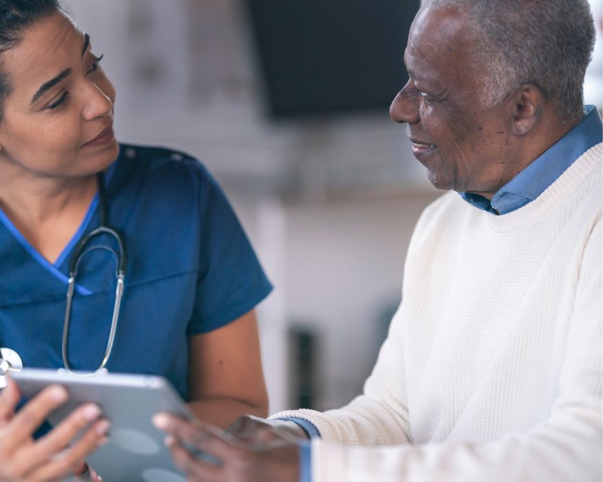 A clinician reviews information on a digital tablet with a patient, demonstrating personalized guidance for allergy and asthma care.